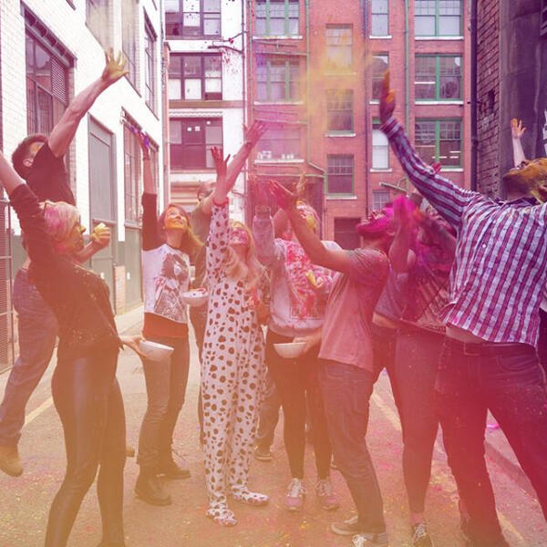 Aimee and group of people throwing colour paint in the air Aimee and group of people throwing colour paint in the air
